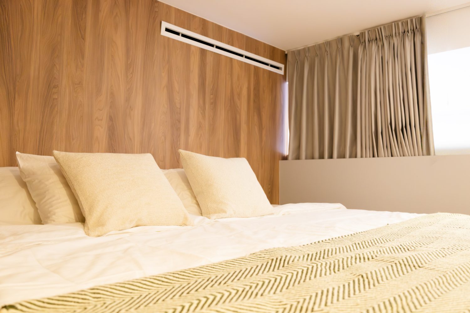 Recámara con cabecera de madera y textiles cálidos, modelo Gala